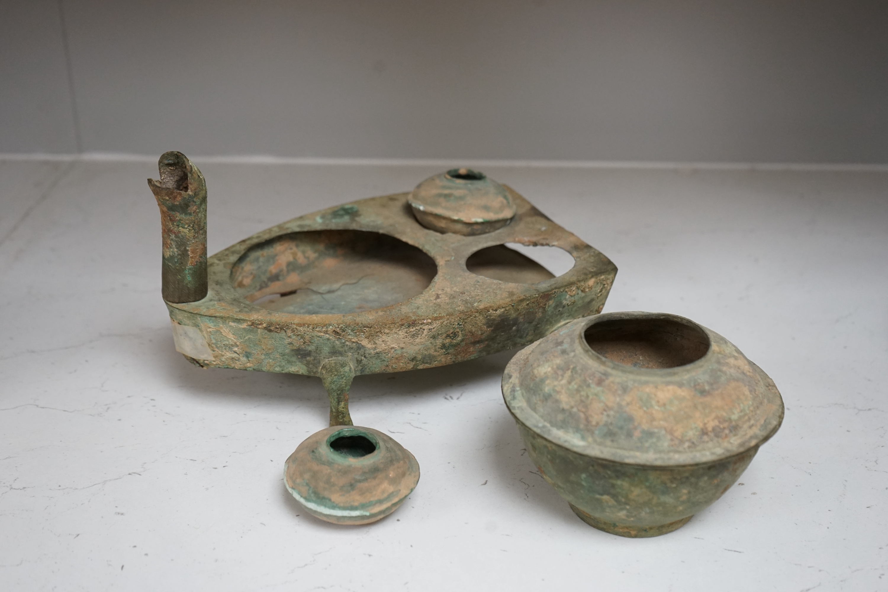 Four Chinese bronze zoomorphic stoves, Han Dynasty, 22cm, together with a Han Dynasty bronze brazier and vessels, width 22.5cm, (5). Condition - poor to fair.